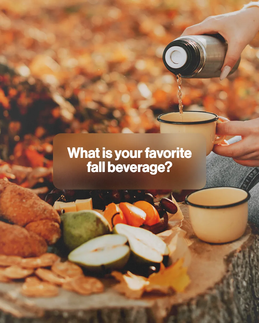 Warm drink poured into a cup, surrounded by fall fruits and snacks on a wooden stump, evoking community and fellowship.