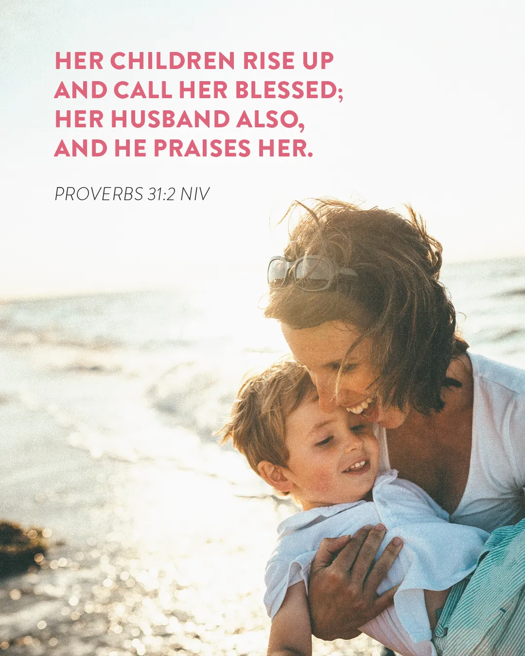 Mother and child embrace by the beach, reflecting Proverbs 31:28 about being blessed and praised.