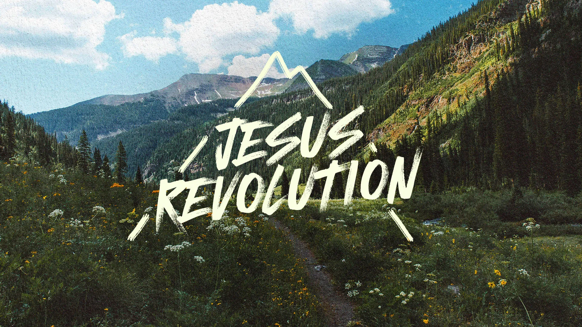 Jesus Revolution church media graphic with handwritten white typography overlaying scenic mountain valley landscape with wildflowers and blue sky