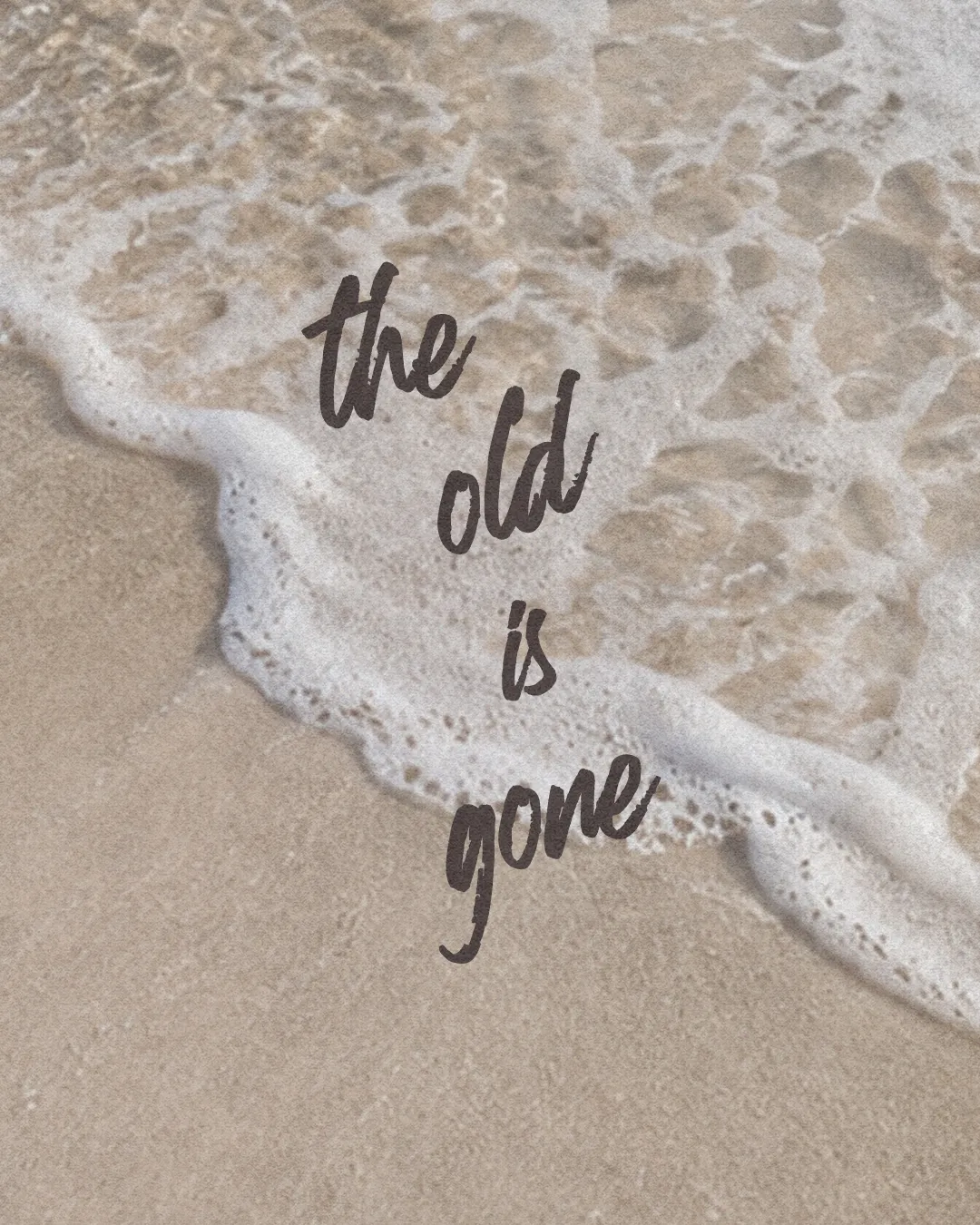 Waves gently wash ashore on sandy beach, with the words "the old is gone" symbolizing renewal and transformation in faith.