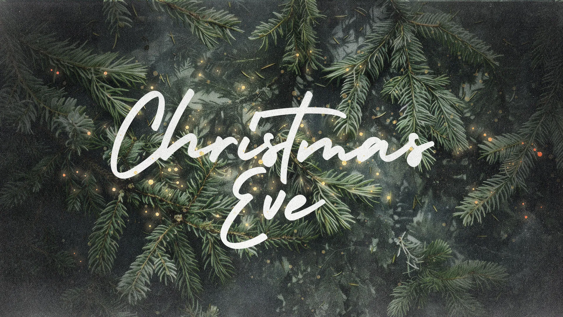 Christmas Eve text in white hand-lettered calligraphy overlaid on dark evergreen pine branches with soft glowing lights creating a peaceful ambiance
