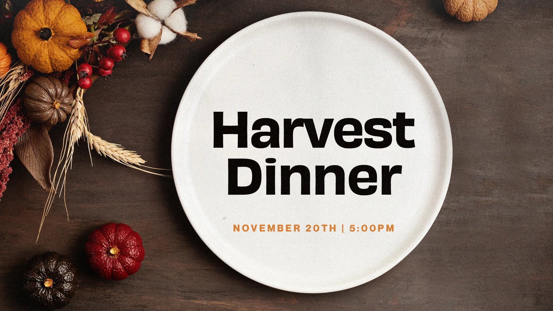Harvest Dinner announcement on white plate surrounded by fall decorations including pumpkins, berries, and wheat