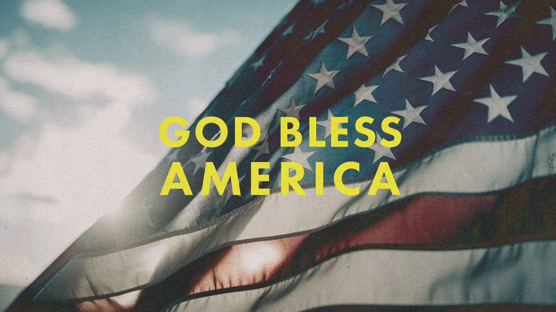 American flag waving with sunlight, featuring the text "God Bless America," symbolizing faith and patriotism.