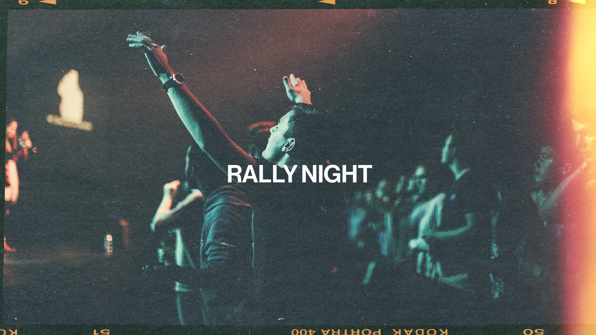 Worshippers raise hands in praise during a vibrant Rally Night, celebrating community and faith together.