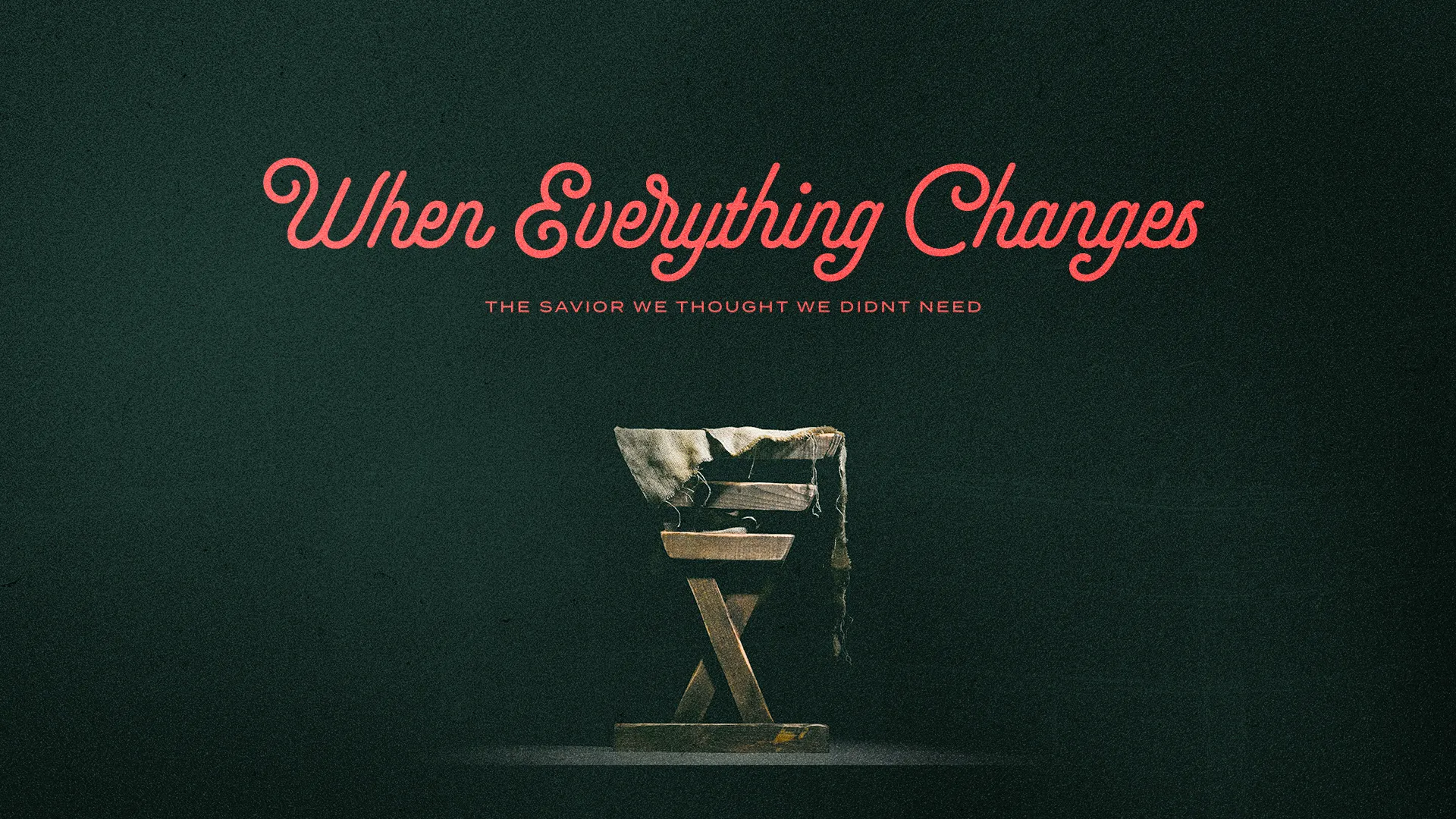 Coral script "When Everything Changes" with "The Savior We Thought We Didn't Need" above a wooden manger on deep teal