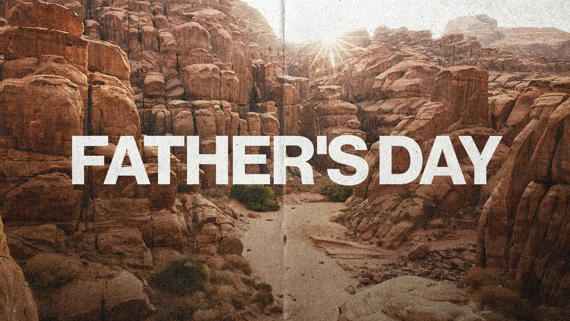 Sunlight breaks over rugged mountains, with "Father's Day" boldly displayed, symbolizing strength and guidance in faith.